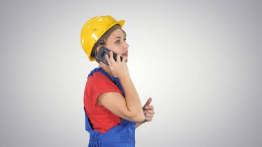 Güzel, genç müteahhit kadın sarı bir kask takıyor.