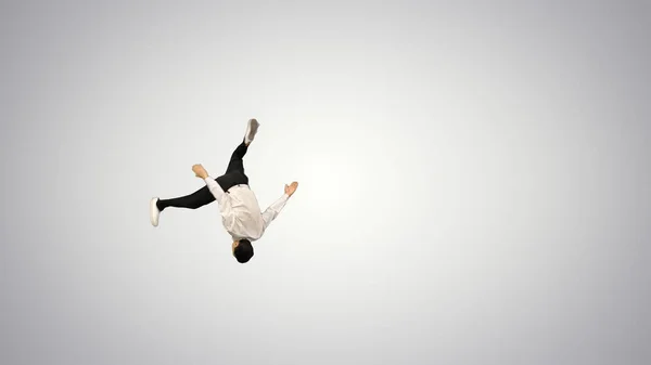 Jovem de camisa branca fazendo back flip olhando para a câmera e w — Fotografia de Stock