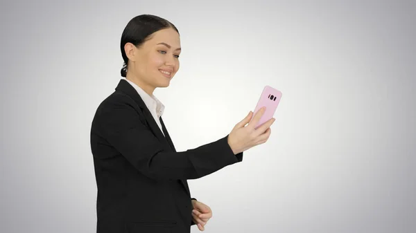 Giovane femmina in un abito avendo business videochiamata sul suo telefono o — Foto Stock