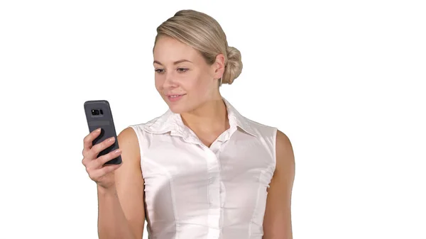 Chica joven leyendo desde la pantalla del teléfono móvil en fondo blanco. — Foto de Stock