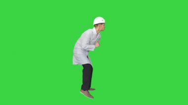 Beyaz cüppeli genç işçi yeşil ekranda dans etmekten zevk alıyor, Chroma Key.