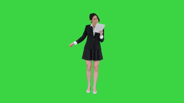 Nette Frau im Rock tanzt und nutzt digitales Tablet auf grünem Bildschirm, Chroma Key. — Stockvideo