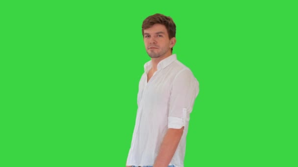 Casual jovem olhando para a câmera e falando sobre algo em uma tela verde, Chroma Key. — Vídeo de Stock