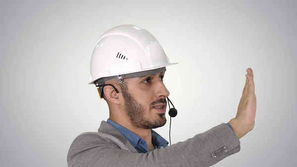 Architekt kontroluje pracę dźwigu rozmawiając przez zestaw słuchawkowy, na gr — Zdjęcie stockowe