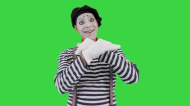 Pandomimci hayali bir duvara dokunuyor ve yeşil ekranda hayali bir kuş yapıyor, Chroma Key.