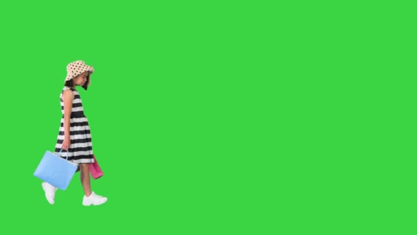 Kleines Mädchen läuft mit Einkaufstaschen auf grünem Bildschirm vorbei, Chroma Key. — Stockvideo