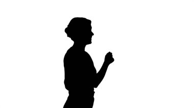 Siluet. Kırmızı tişörtlü, kot pantolonlu, dans eden ve yürüyen genç kadın.