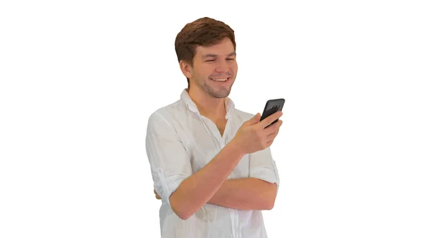 Snygg ung man som använder sin smartphone och skrattar på vit ba — Stockfoto