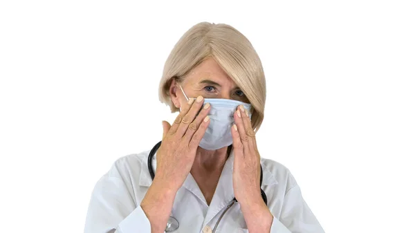 Oudere vrouw in een medisch masker met een stethoscoop op witte rug — Stockfoto