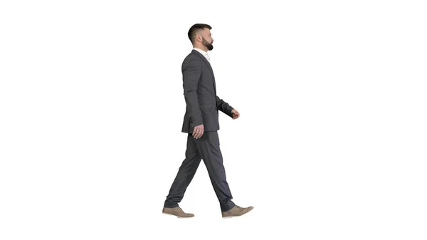 Σοβαρός επιχειρηματίας με επίσημο κοστούμι περπατώντας σε λευκό φόντο. — Φωτογραφία Αρχείου