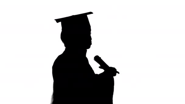 Afro-americana estudiante en bata de graduación hablando por teléfono mientras camina, Alpha Channel — Vídeos de Stock