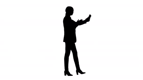 Silhouette Junge Frau in einem Anzug mit Business-Videoanruf auf ihrem Handy. — Stockvideo