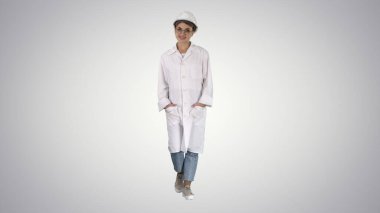 Gradyan laboratuvar önlüklü ve kasklı bir kadın gradyan ba 'da yürüyor.