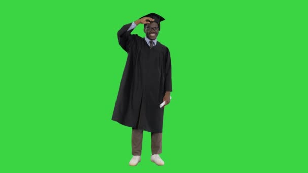 Emocionado estudante afro-americano jogando morteiro no ar e fazendo dança boba com seu diploma em uma tela verde, Chroma Key. — Vídeo de Stock