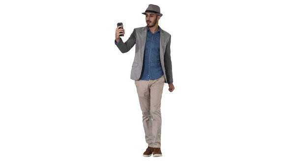 Attractive man in casual clothes hat hipster stylerecording vlog or making a video call on white background.