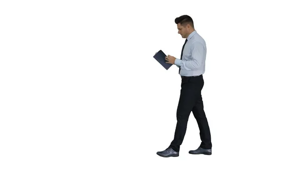 Young confused man trying to read smart book misunderstanding content while walking on white background. — Stock Photo, Image