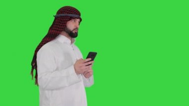 Arap adam internette akıllı telefon sörfü yapıyor ya da yeşil ekranda mesajlaşıyor, Chroma Key.