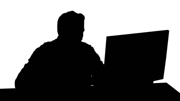 Silhouette Poważny gracz siedzi przy komputerze i ogląda mecz. — Zdjęcie stockowe