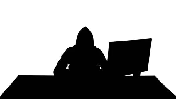 Silhouette Hooded Hacker mit Laptop und Smartphone. — Stockfoto