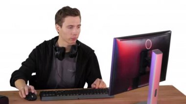 Gergin adam beyaz arka planda bilgisayar başında video oyunları izliyor..