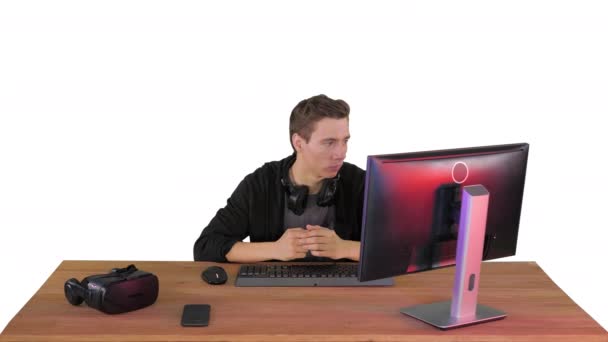 Serious gamer sitting at computer watching a game on white background. — Stock Video