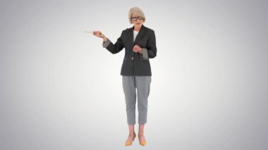 Eğilimli arka planda bir şeyi açıklayan ve işaret eden kendinden emin son sınıf öğretmeni..