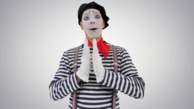 Pandomimci hayali duvara dokunuyor ve gradyan arkaplanda hayali kuş yapıyor.