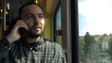 Trende telefonla konuşan yakışıklı adam..