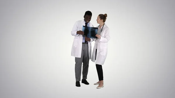 年轻的女医生和非洲裔美国医生正在看X光透视片 — 图库照片
