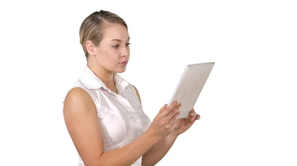 Mooie vrouw staande en met behulp van een tablet op witte achtergrond. — Stockfoto