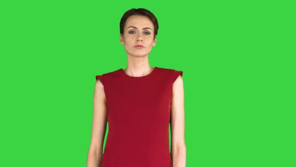 赤いドレスの女の子、ポーズをとって、緑色の画面上で彼女のドレスをまっすぐに、クロマキー. — ストック動画
