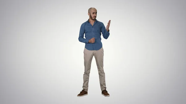 Arabski młody człowiek w koszuli mówi coś prezentując i punkt — Zdjęcie stockowe