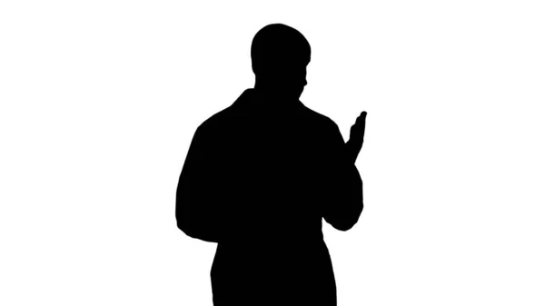 Silhouette Médecin d'âge moyen homme portant l'uniforme médical présentant et pointant avec la paume de la main regardant la caméra. — Photo