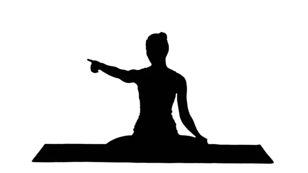 Silhouette Young attractive woman sitting in lotus pose and pointing at something or someone while talking. — Stock Photo, Image