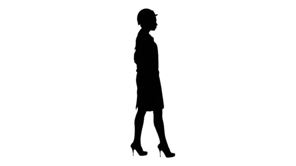 Silhouette Donna in vestaglia bianca indossando un cappello duro mentre si cammina — Foto Stock