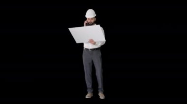 Formalite ve başlık mühendisi cep telefonuyla müşteri ya da müteahhit ile konuşuyor ve Alpha Channel 'ın planına bakıyor.
