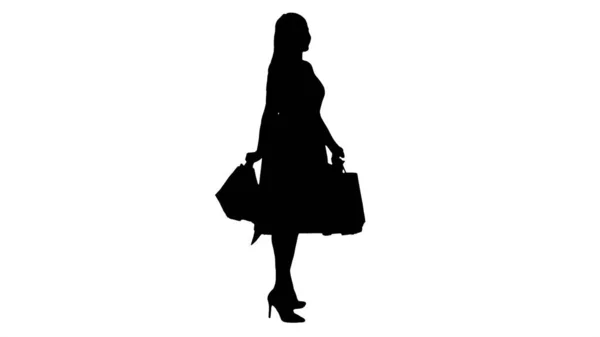 Silhouette Feliz joven mujer haciendo un giro con bolsas de compras en —  Fotos de Stock