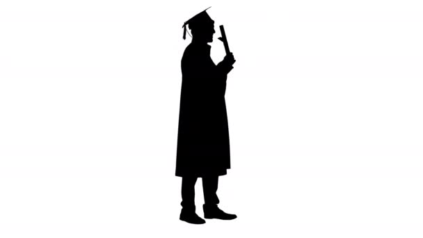 Silhouette Sonriente estudiante masculino en bata de graduación posando con diploma. — Vídeos de Stock