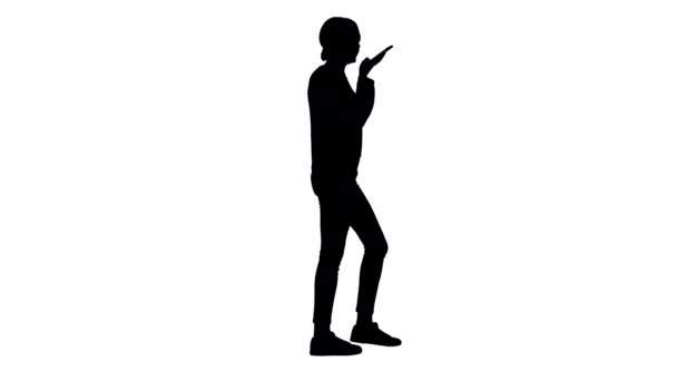 Silhouette Young woman talking on the phone holding it to her face while walking. — Stock Video