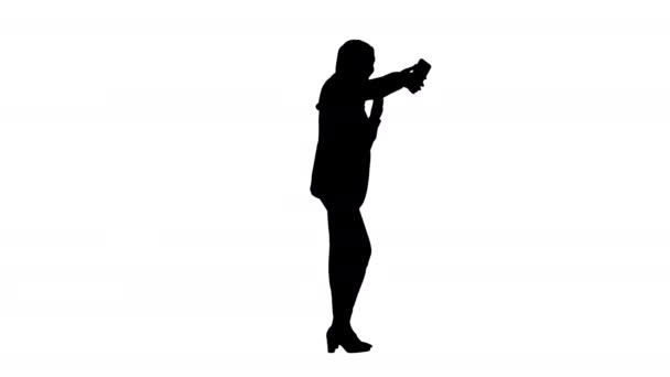 Silhouette Lächelnde Araberin im Hidschab macht Selfie-Fotos mit ihrem Handy. — Stockvideo