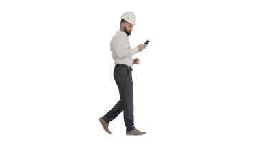 Beyaz arkaplanda yürüyen ve akıllı telefon kullanan bir mühendis.