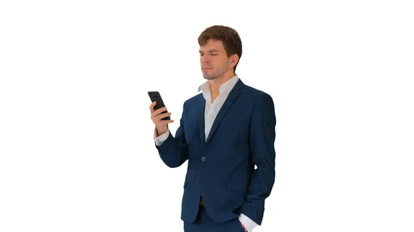 Hombre de negocios serio mirando su teléfono sobre fondo blanco. — Foto de Stock