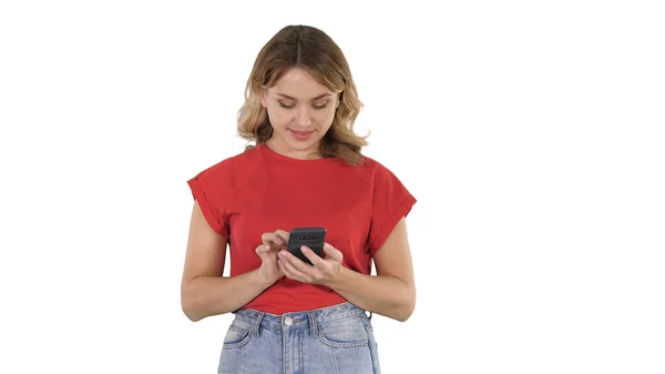 Jovem mulher bonita em t-shirt usando seu smartphone no branco b — Fotografia de Stock