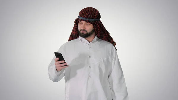 Arabisk man som använder sin smartphone surfa på internet eller messagi — Stockfoto