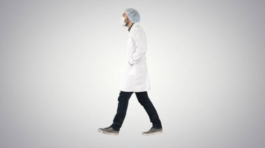 Yürüyen doktor gradyan arka plana tıbbi maske takıyor..