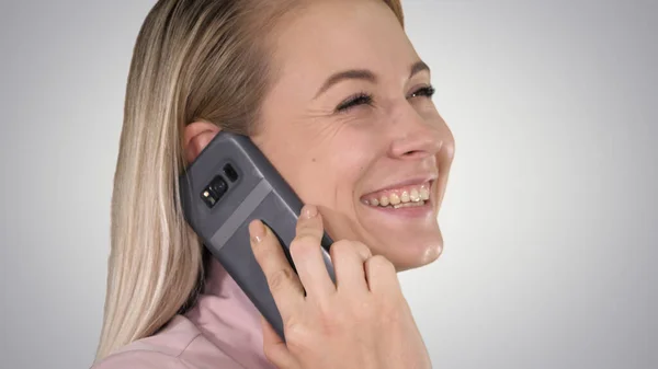 Sonriente rubia hablando por teléfono sobre fondo degradado. — Foto de Stock