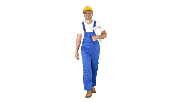 Trabajador de la construcción caminando con estampados azules y sonriendo a la cámara sobre fondo blanco. — Foto de Stock