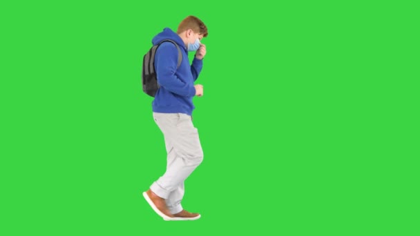 의료용 마스크를 쓴 채그린 스크린, 크로마 키 위를 걷고 있는 학생. — 비디오