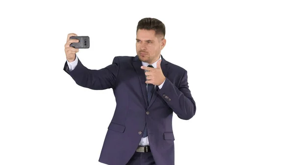 Schöner Mann im Anzug macht ein Selfie beim Gehen auf weißem Hintergrund. — Stockfoto