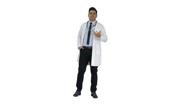 Vriendelijke en speelse mannelijke arts en zelfverzekerd praten met camera op witte achtergrond. — Stockfoto
